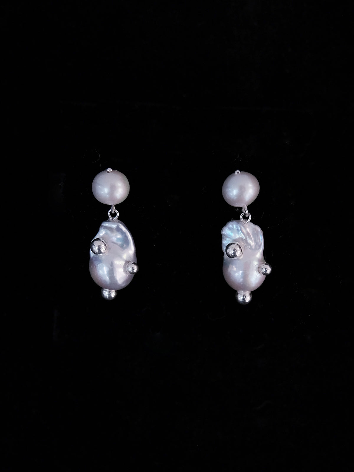 Helmia Orbita Stud Drop -korvakorut mustalla taustalla